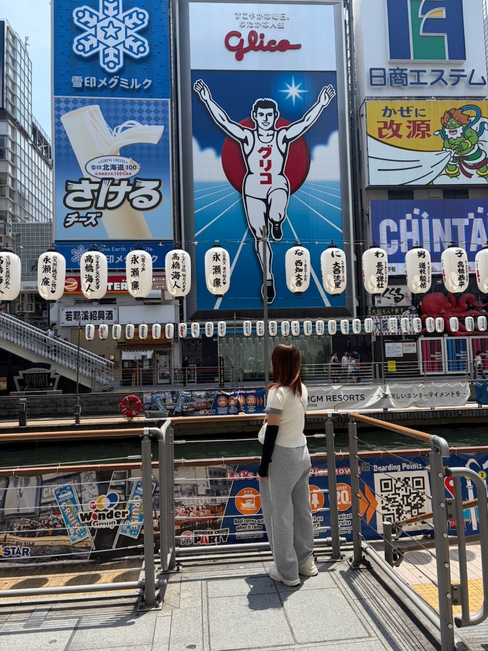 グレー系のスウェットパンツ、ホワイト系のニット/セーター、ホワイト系のショルダーバッグを着用したレディースの夏コーディネートの2枚目の写真