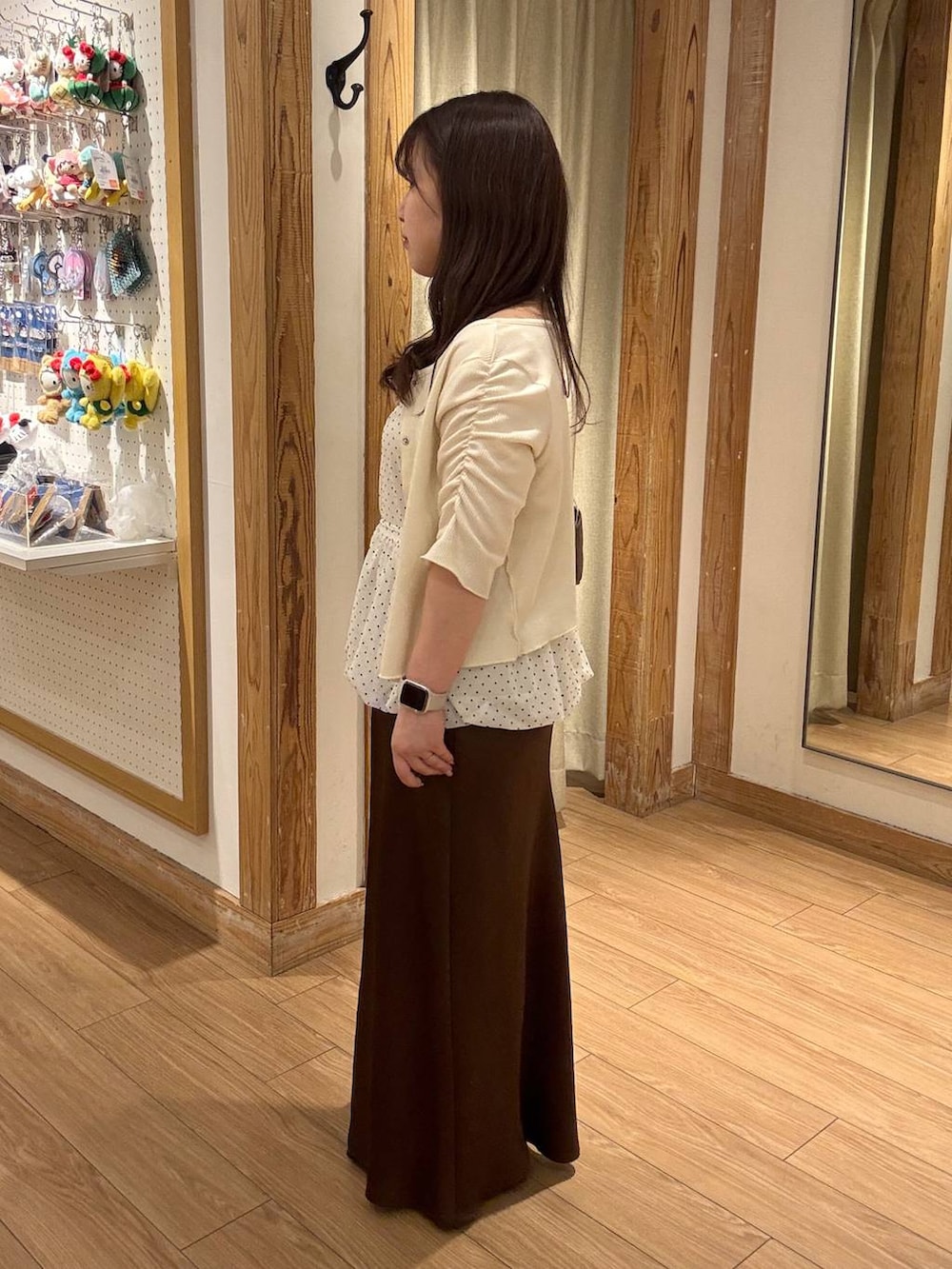 ブラウン系のスカート、ブラウン系のショルダーバッグ、ホワイト系のTシャツ/カットソーを着用したレディースの春コーディネートの2枚目の写真