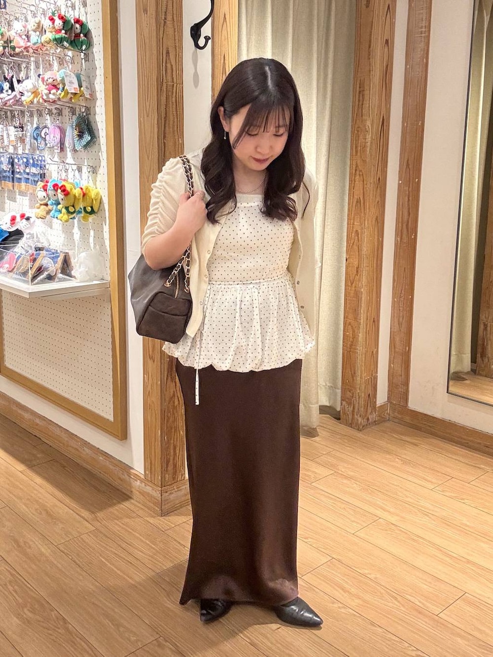 ブラウン系のスカート、ブラウン系のショルダーバッグ、ホワイト系のTシャツ/カットソーを着用したレディースの春コーディネートの4枚目の写真