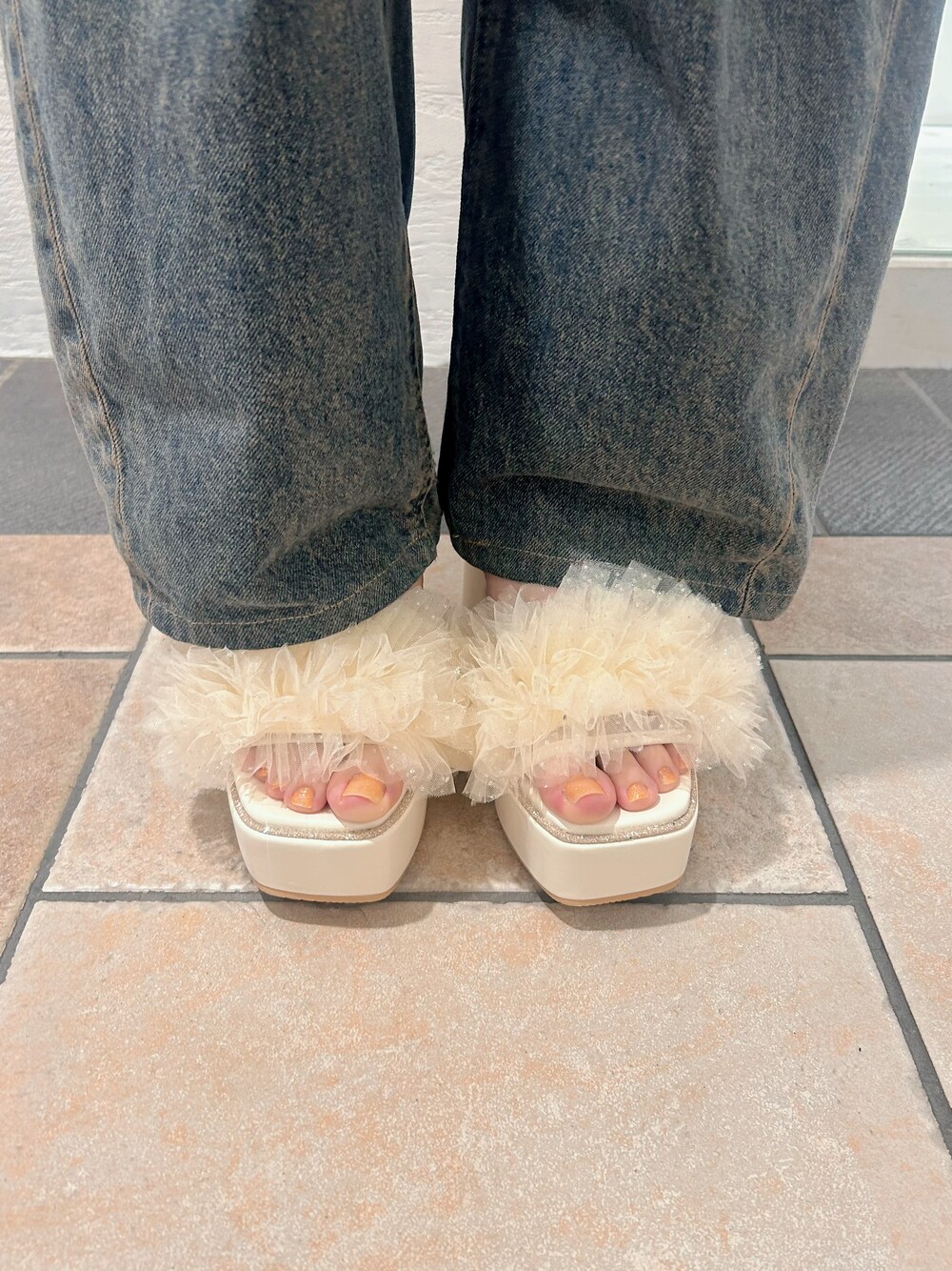 ホワイト系のサンダルを着用したレディースの春コーディネートの6枚目の写真