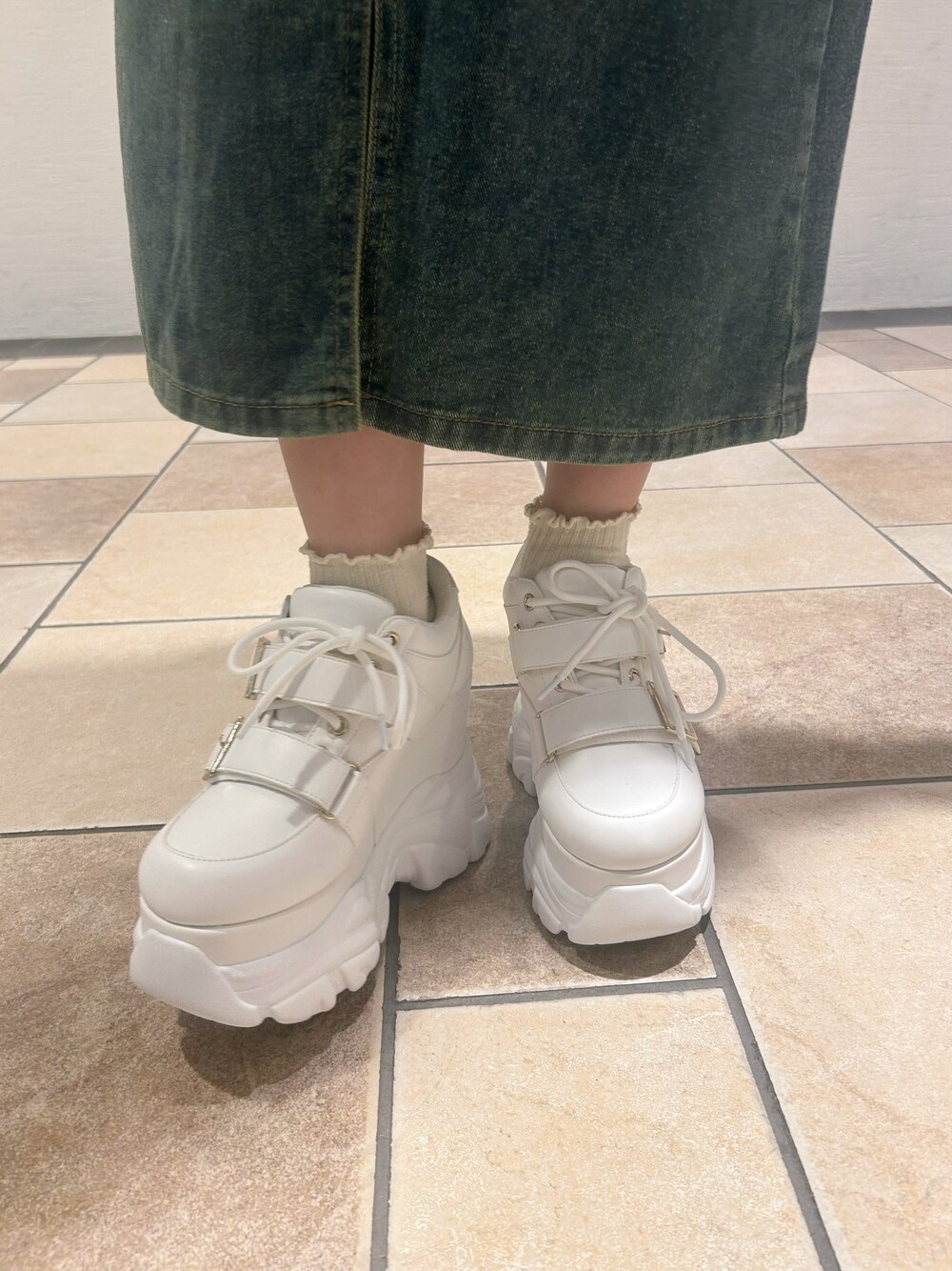ホワイト系のスニーカーを着用したレディースの春コーディネートの6枚目の写真
