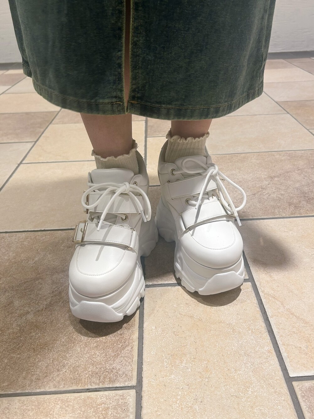 ホワイト系のスニーカーを着用したレディースの春コーディネートの9枚目の写真