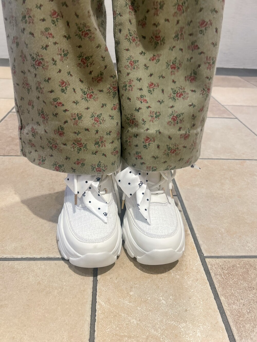 ホワイト系のスニーカーを着用したレディースの夏コーディネートの7枚目の写真