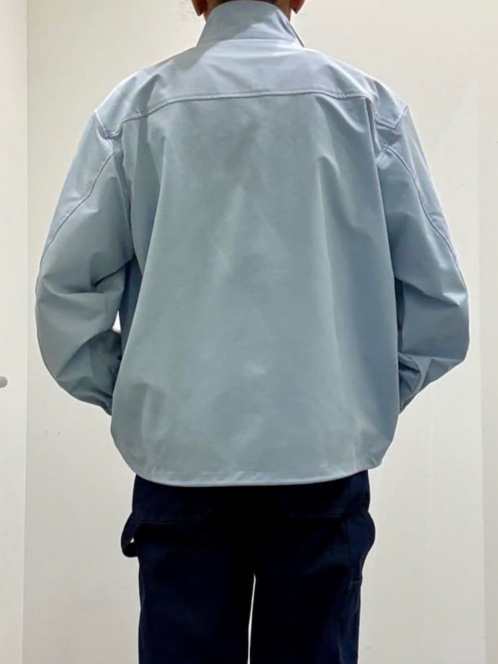 ホワイト系のニット/セーター、グレー系のスリッポン、ブルー系のデニムパンツを着用したメンズの夏コーディネートの6枚目の写真