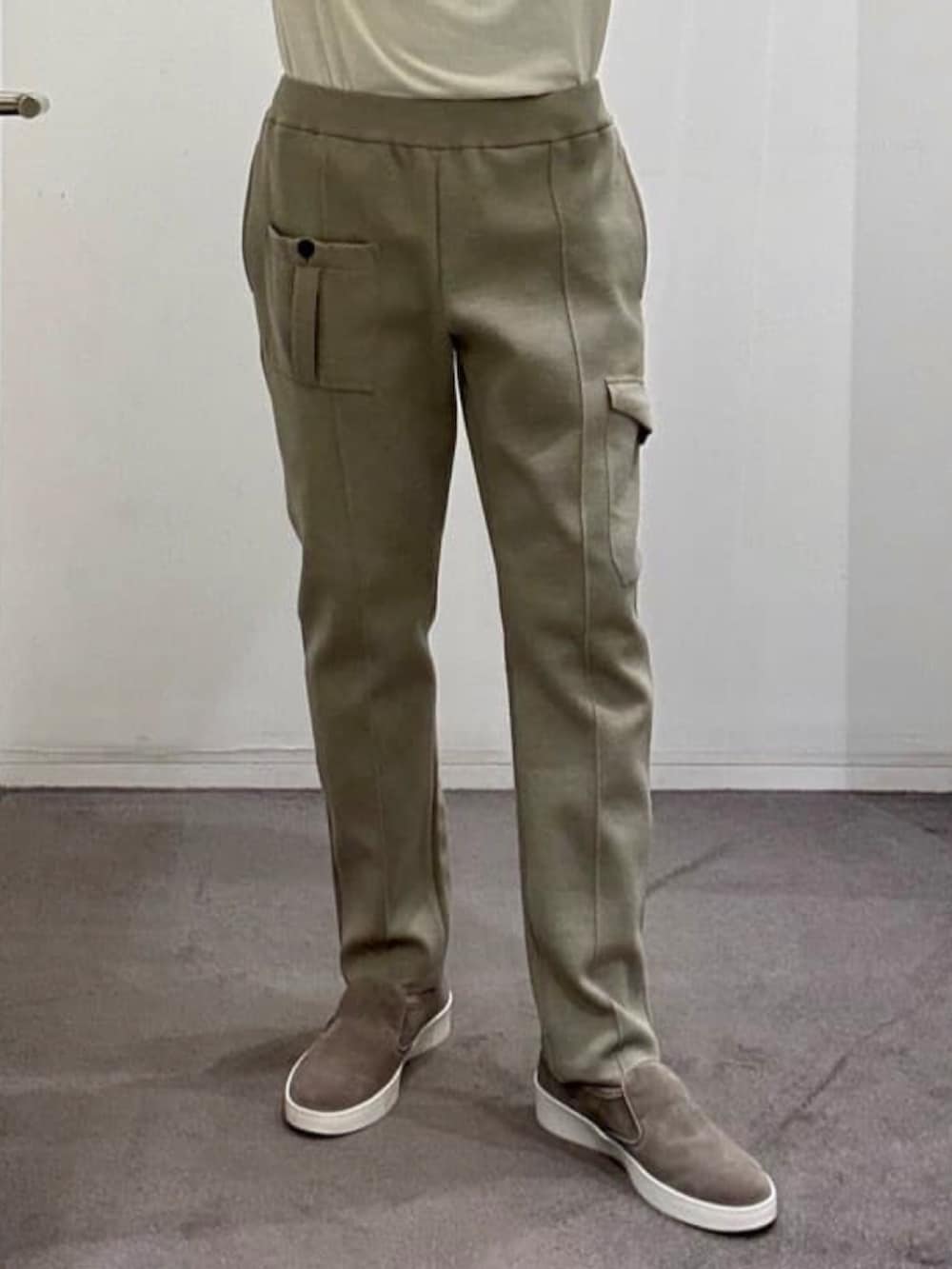 ベージュ系のブルゾン、ホワイト系のニット/セーター、ベージュ系のスラックスを着用したメンズの夏コーディネートの7枚目の写真