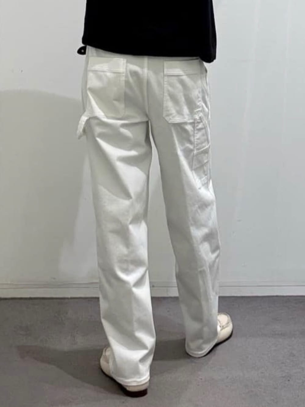 ホワイト系のデニムパンツ、グレー系のショルダーバッグ、ブラック系のポロシャツを着用したメンズの夏コーディネートの8枚目の写真