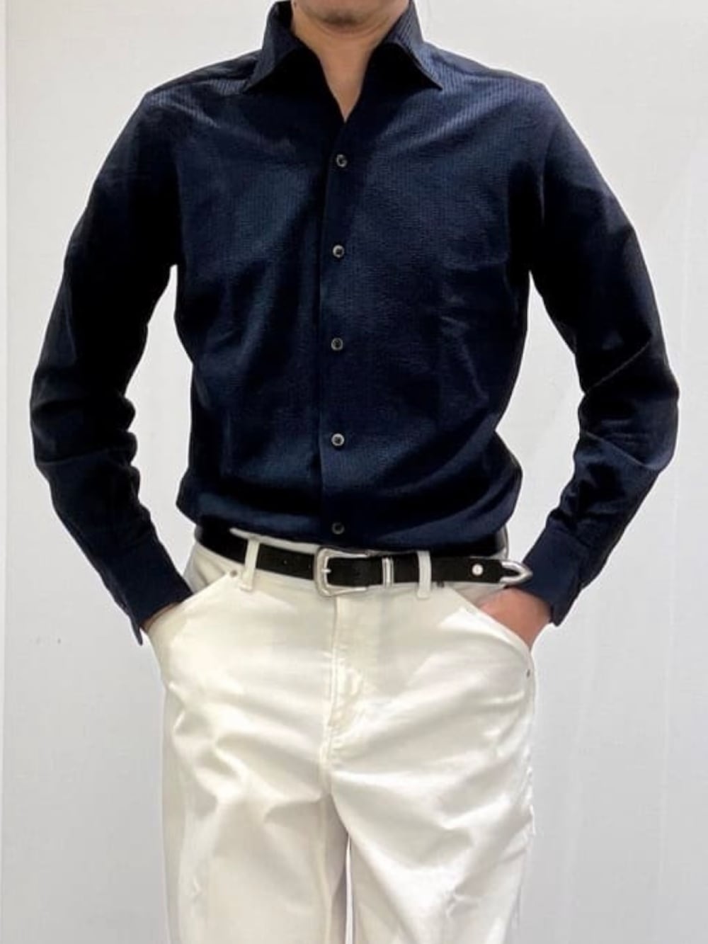 ブラック系のドレスシューズ、ホワイト系のデニムパンツ、ブルー系のニット/セーターを着用したメンズの春コーディネートの7枚目の写真
