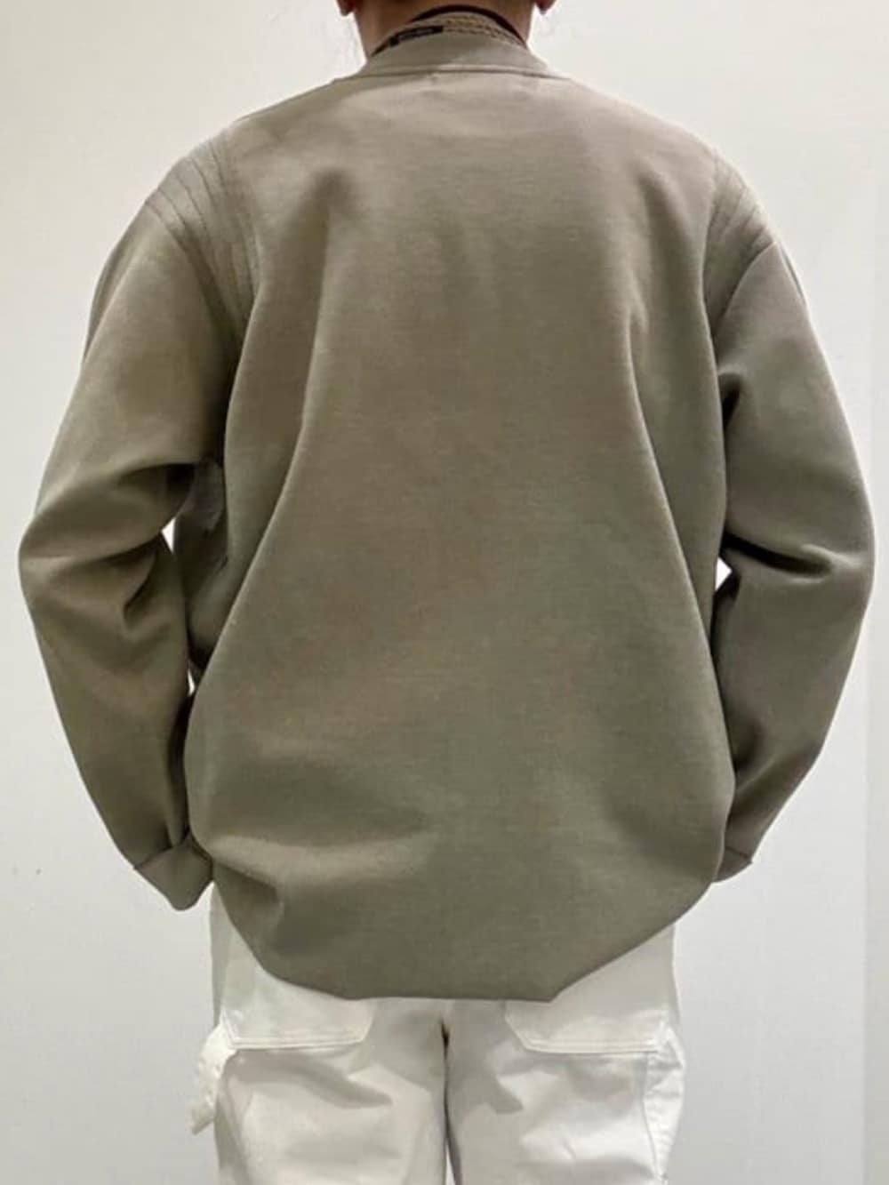 ブラック系のドレスシューズ、ホワイト系のデニムパンツ、ベージュ系のニット/セーターを着用したメンズの春コーディネートの6枚目の写真