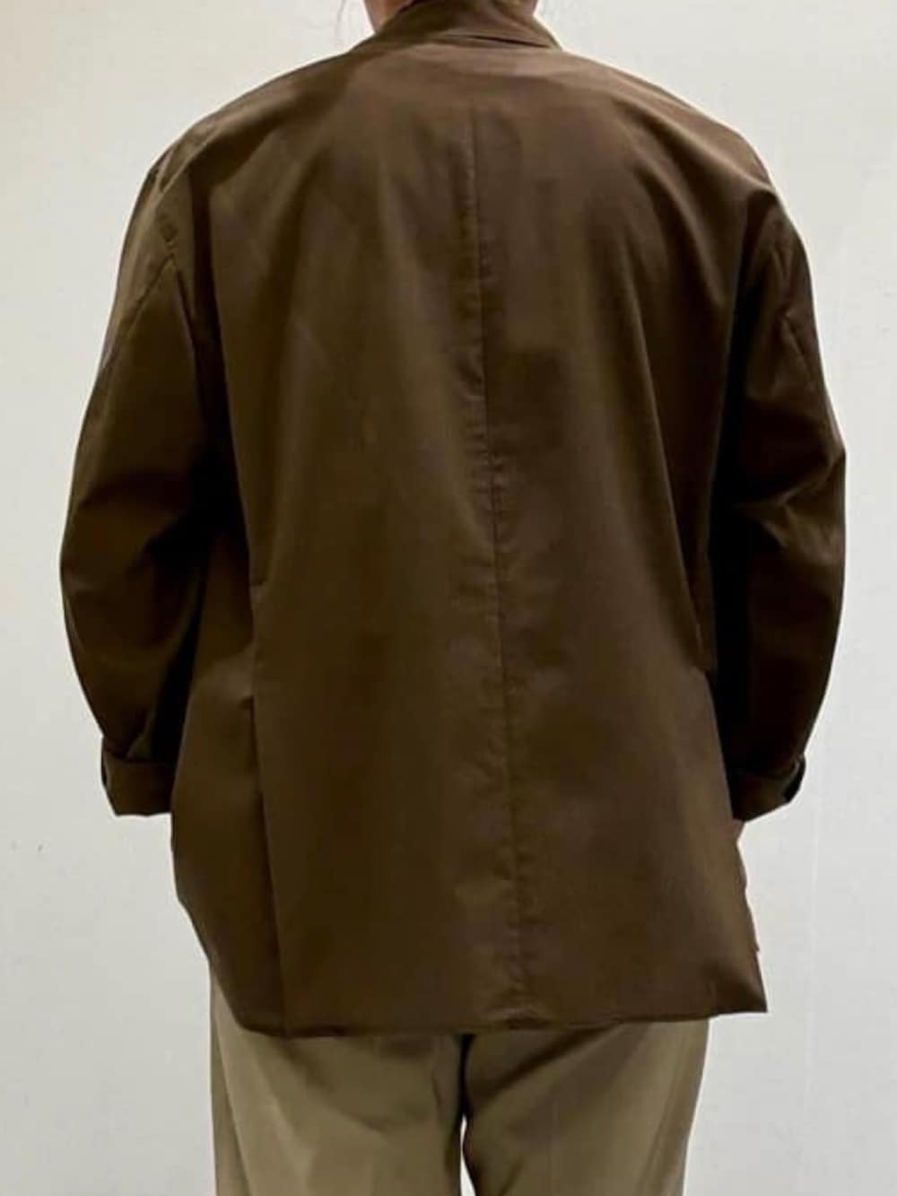 ブラウン系のテーラードジャケット、ブラック系のTシャツ/カットソー、ベージュ系のスラックスを着用したメンズの夏コーディネートの6枚目の写真