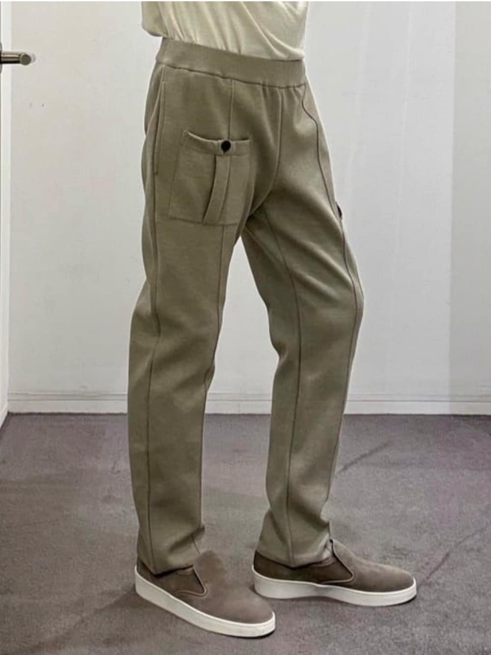 ベージュ系のブルゾン、ホワイト系のニット/セーター、ベージュ系のスラックスを着用したメンズの夏コーディネートの8枚目の写真