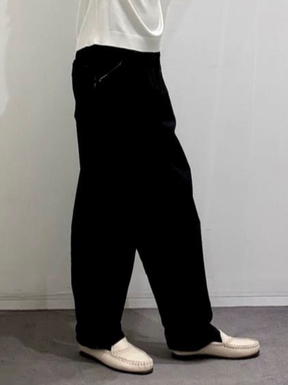 ベージュ系のスリッポン、ブラック系のデニムパンツ、ホワイト系のニット/セーターを着用したメンズの春コーディネートの9枚目の写真