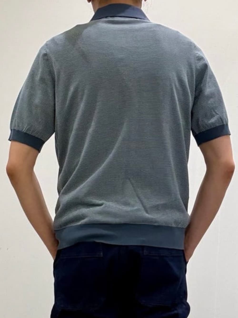 グレー系のスリッポン、ブルー系のテーラードジャケット、ブルー系のデニムパンツを着用したメンズの夏コーディネートの8枚目の写真