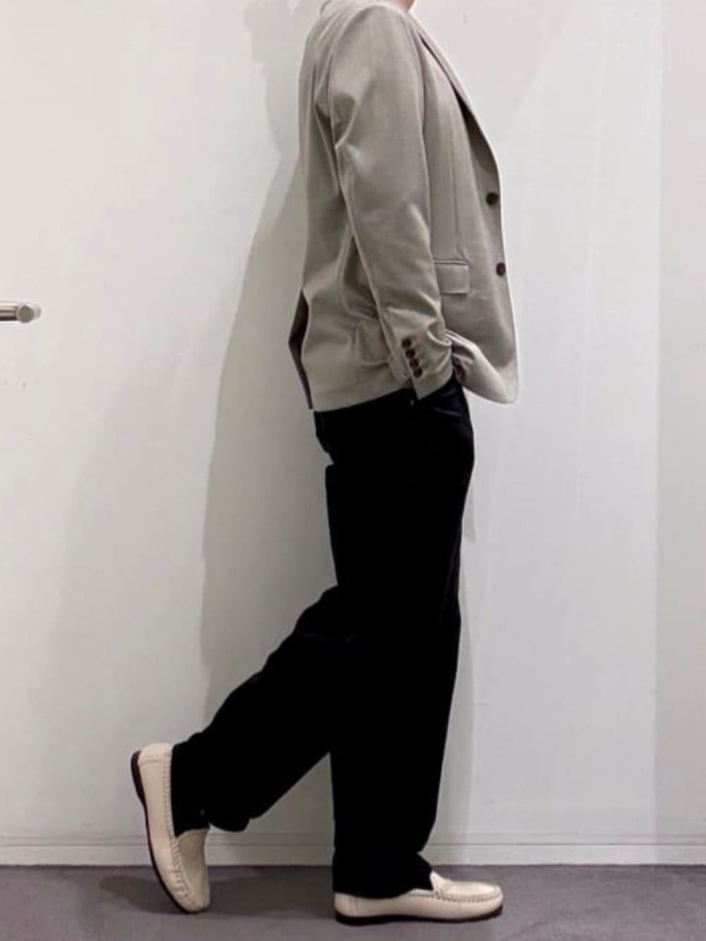 ベージュ系のスリッポン、ブラック系のデニムパンツ、ホワイト系のニット/セーターを着用したメンズの春コーディネートの2枚目の写真