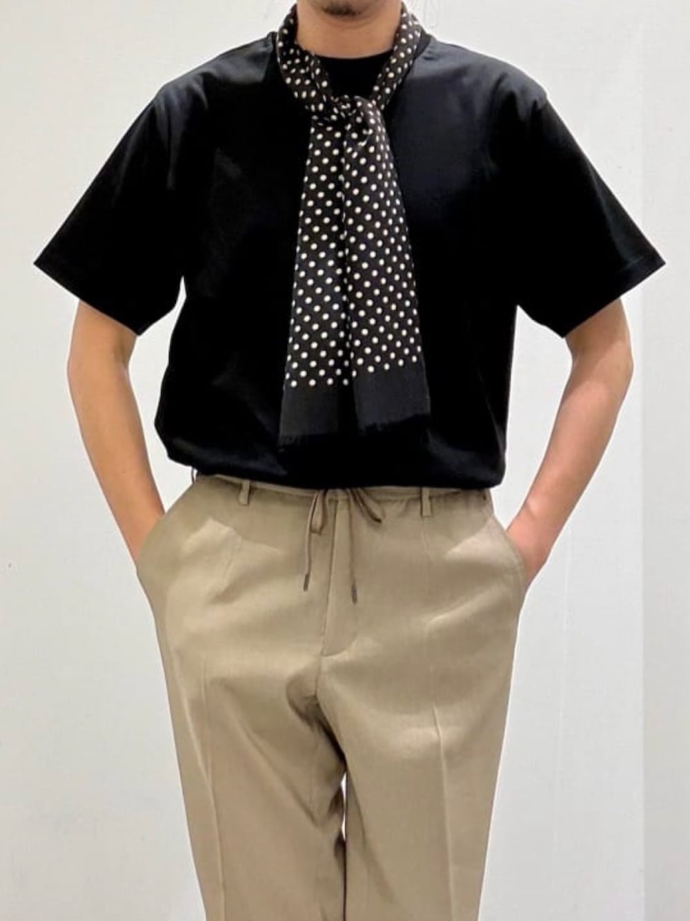 ブラウン系のテーラードジャケット、ブラック系のTシャツ/カットソー、ベージュ系のスラックスを着用したメンズの夏コーディネートの7枚目の写真
