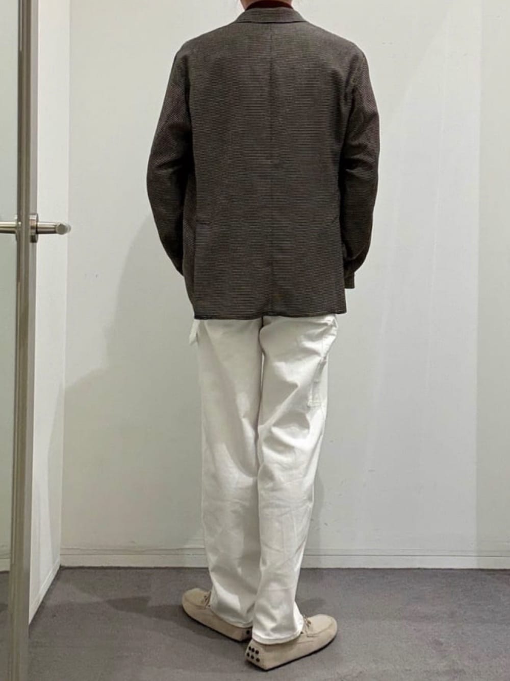 ホワイト系のデニムパンツ、グレー系のスリッポン、ブラウン系のポロシャツを着用したメンズの夏コーディネートの3枚目の写真