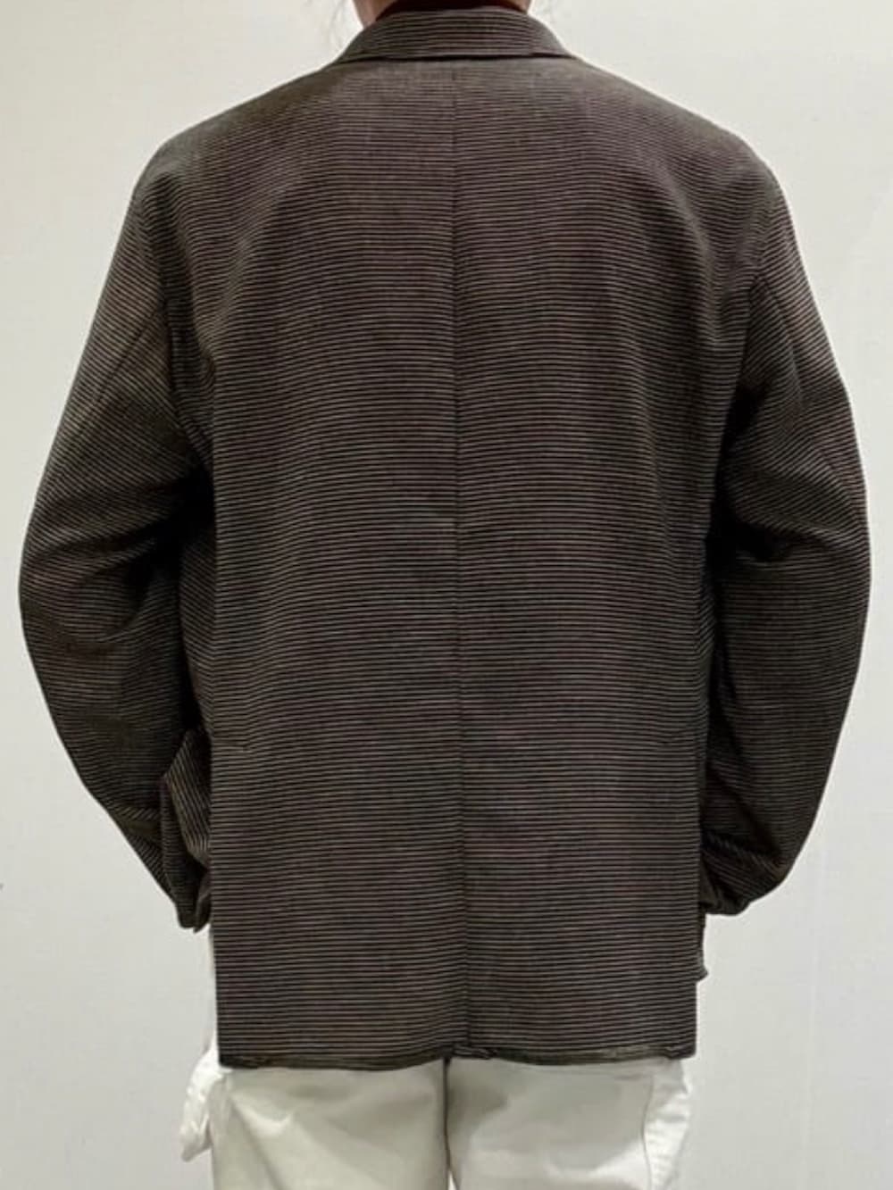 ホワイト系のデニムパンツ、グレー系のスリッポン、ブラウン系のポロシャツを着用したメンズの夏コーディネートの6枚目の写真