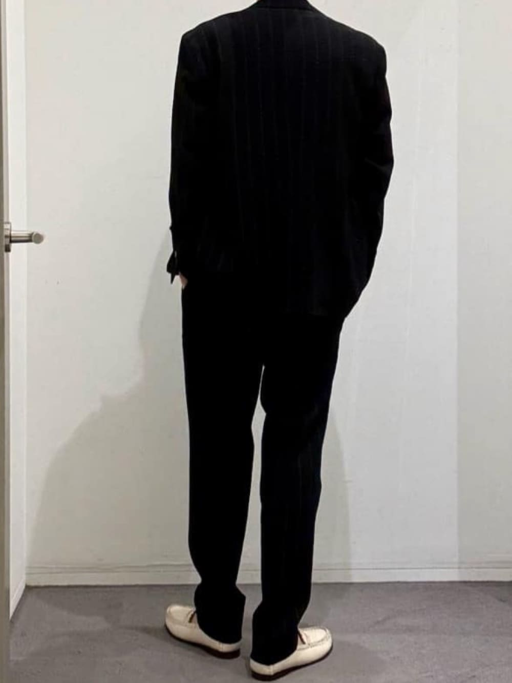 ブラック系のテーラードジャケット、ブラック系のショルダーバッグ、ブラック系のスラックスを着用したメンズの夏コーディネートの3枚目の写真