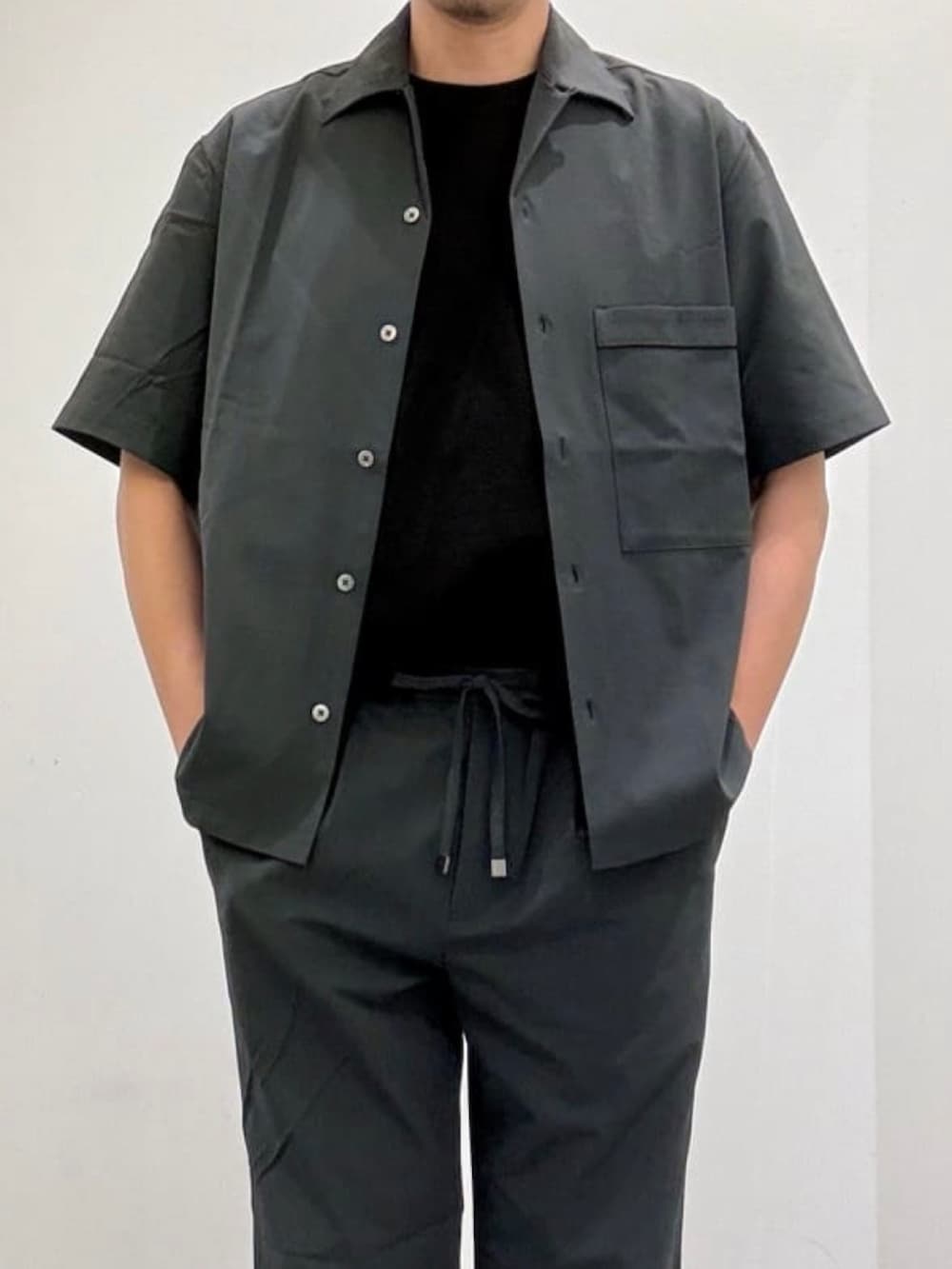 ブラック系のドレスシューズ、グレー系のスラックス、グレー系のシャツ/ブラウスを着用したメンズの夏コーディネートの4枚目の写真