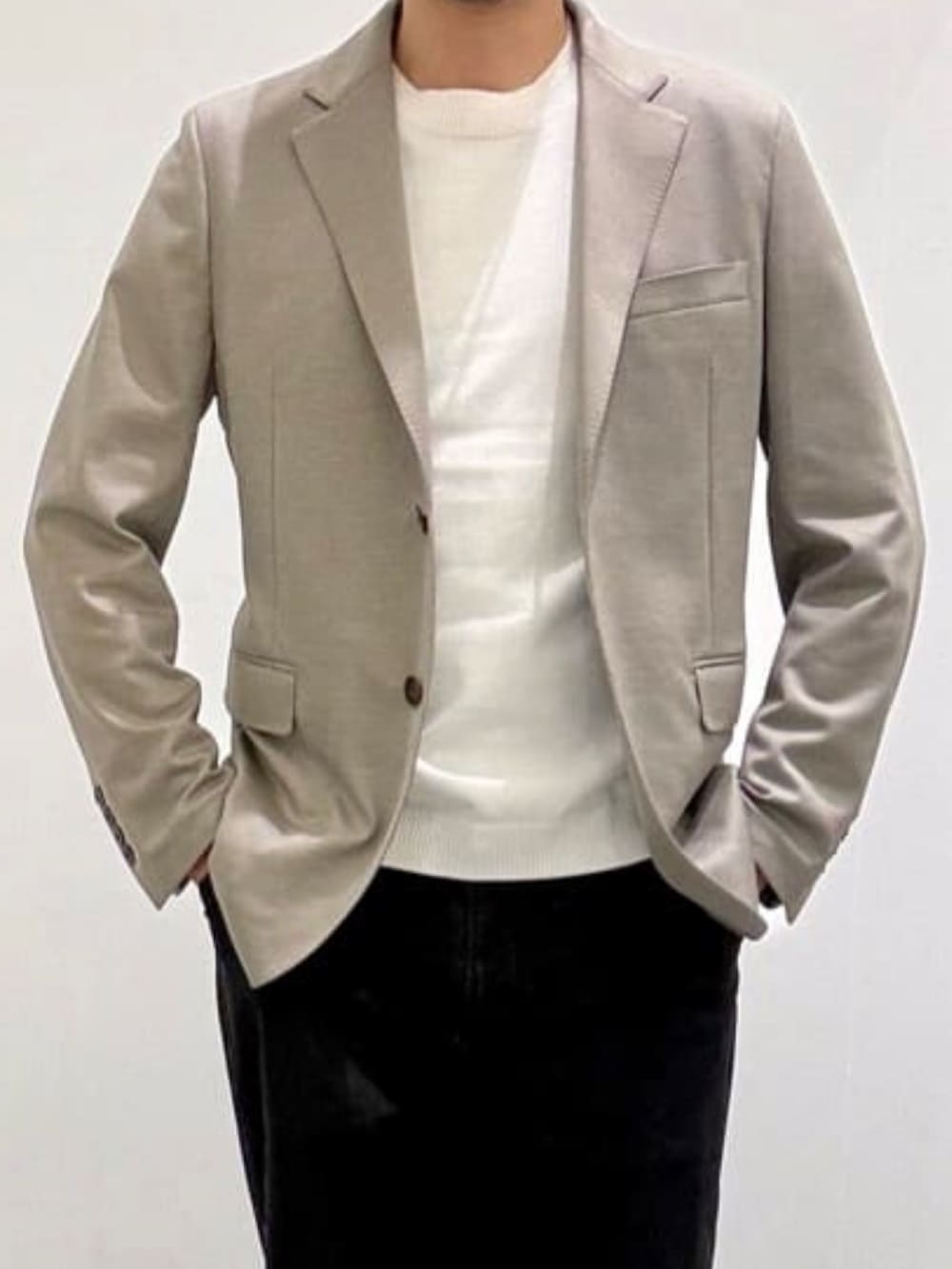 ベージュ系のスリッポン、ブラック系のデニムパンツ、ホワイト系のニット/セーターを着用したメンズの春コーディネートの4枚目の写真