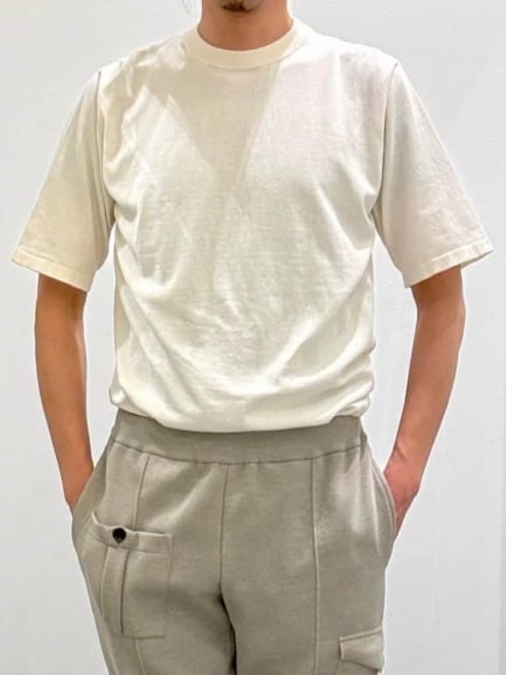 ベージュ系のブルゾン、ホワイト系のニット/セーター、ベージュ系のスラックスを着用したメンズの夏コーディネートの5枚目の写真