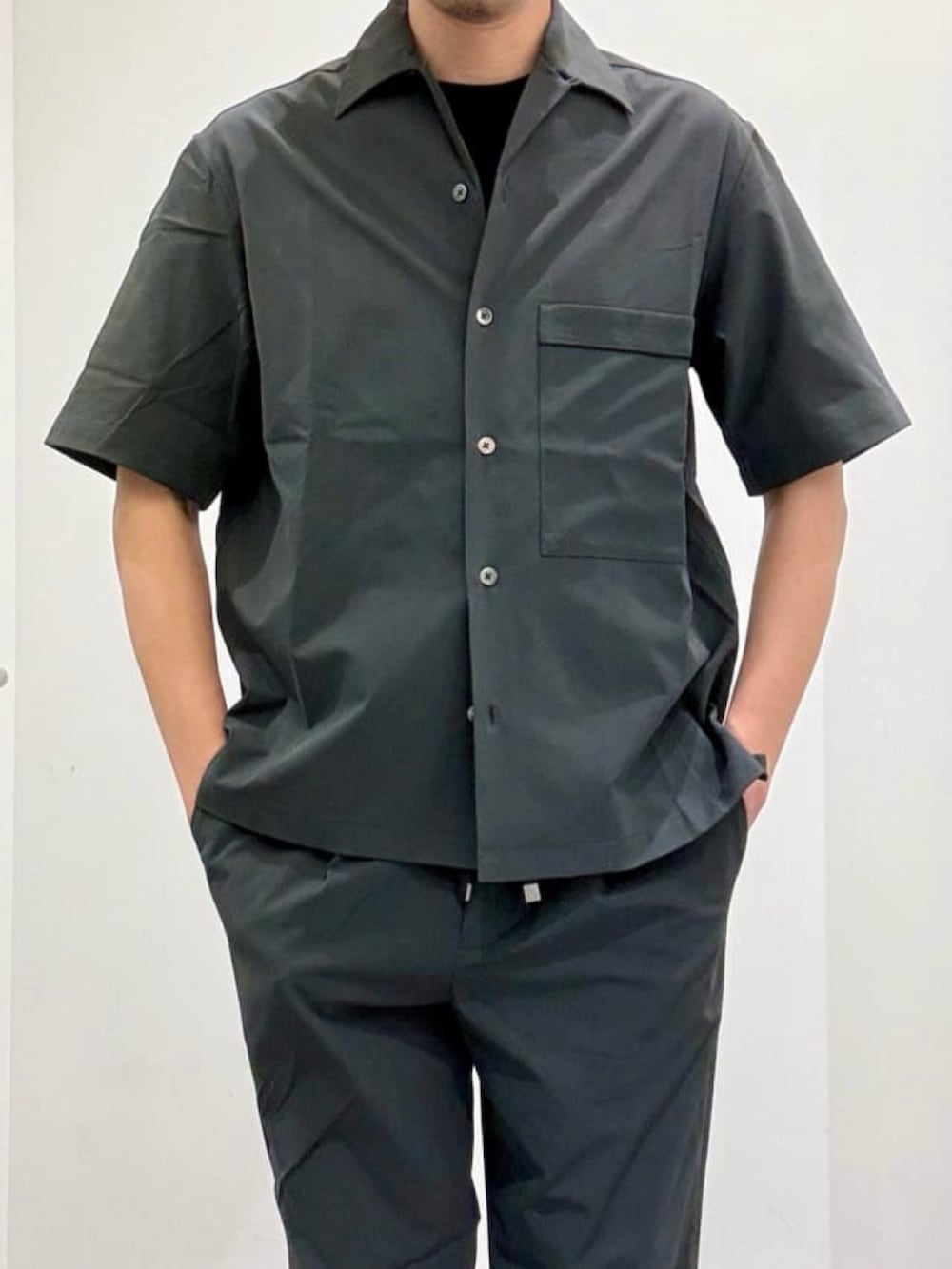 ブラック系のドレスシューズ、グレー系のスラックス、グレー系のシャツ/ブラウスを着用したメンズの夏コーディネートの5枚目の写真
