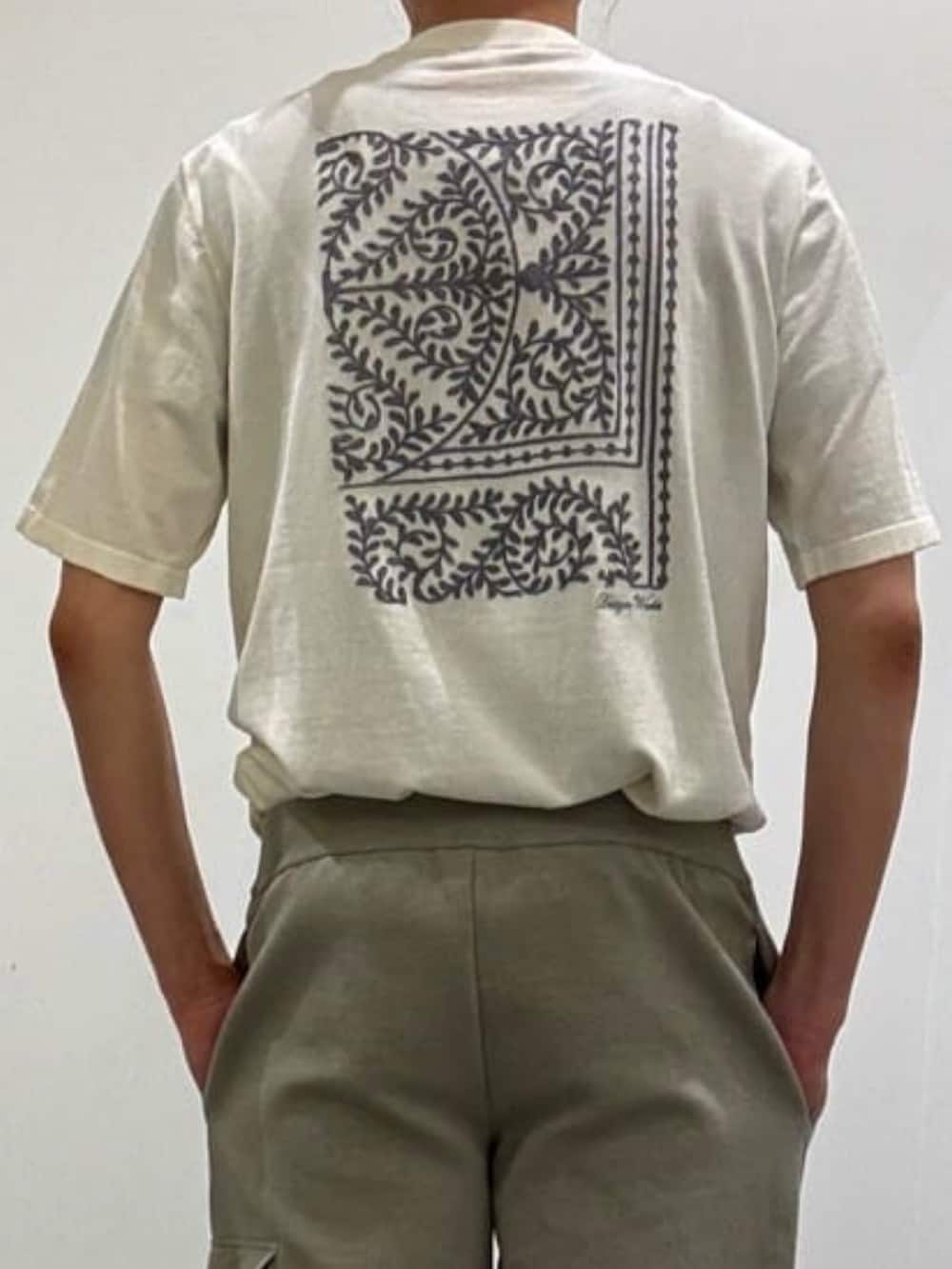 ベージュ系のブルゾン、ホワイト系のニット/セーター、ベージュ系のスラックスを着用したメンズの夏コーディネートの6枚目の写真
