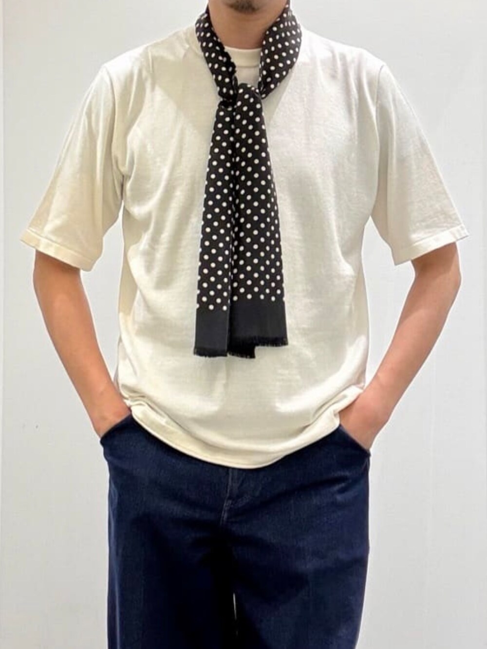 ホワイト系のニット/セーター、グレー系のスリッポン、ブルー系のデニムパンツを着用したメンズの夏コーディネートの7枚目の写真