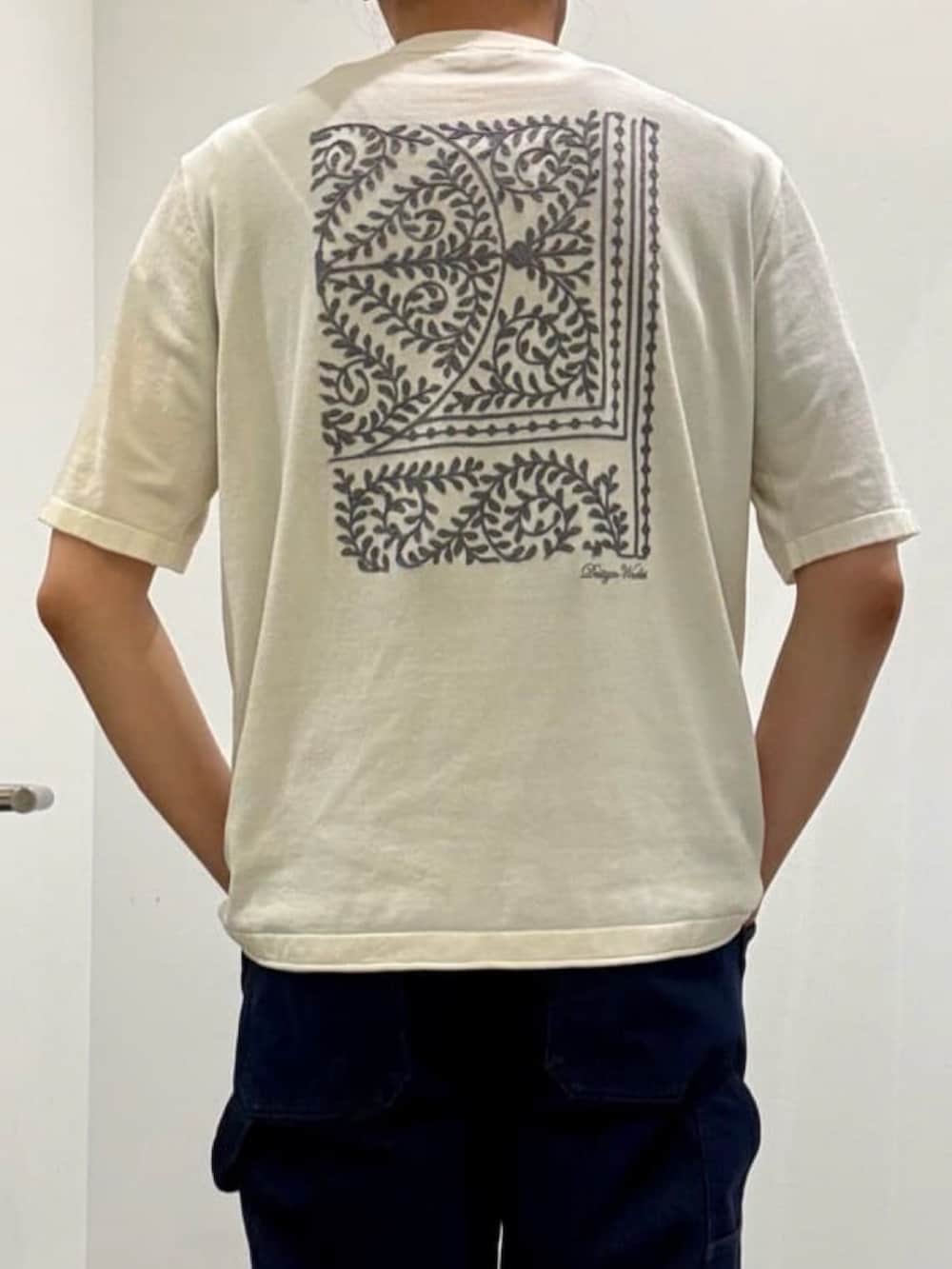 ホワイト系のニット/セーター、グレー系のスリッポン、ブルー系のデニムパンツを着用したメンズの夏コーディネートの9枚目の写真