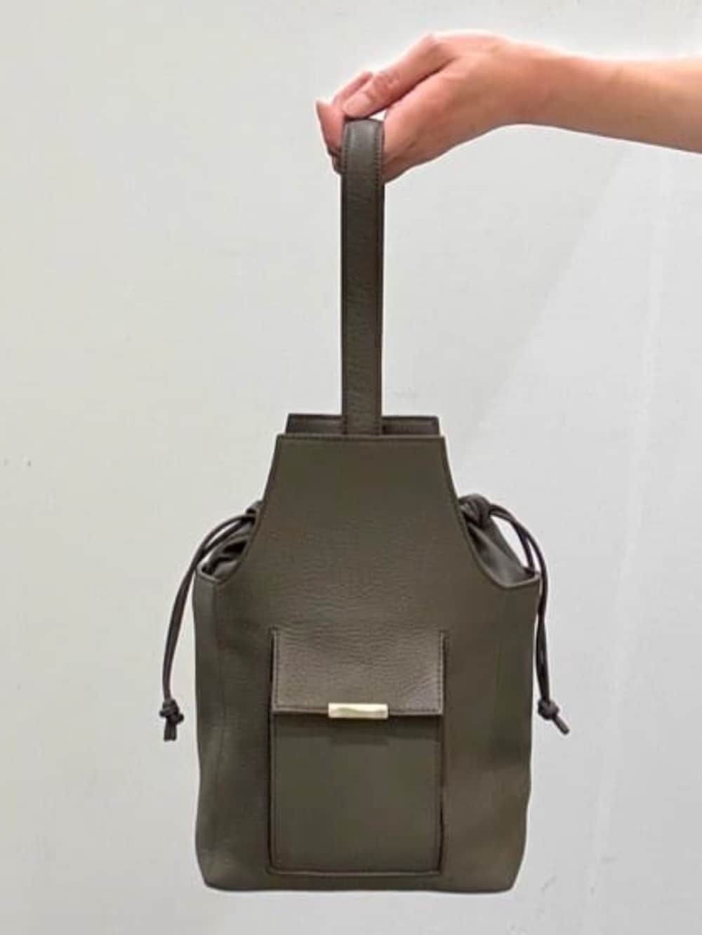 ホワイト系のデニムパンツ、グレー系のショルダーバッグ、ブラック系のポロシャツを着用したメンズの夏コーディネートの9枚目の写真