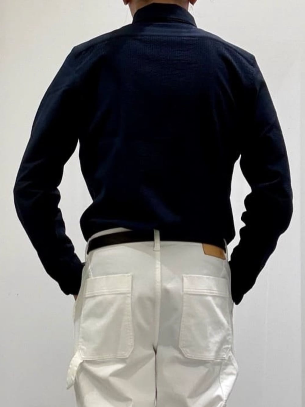 ブラック系のドレスシューズ、ホワイト系のデニムパンツ、ブルー系のニット/セーターを着用したメンズの春コーディネートの8枚目の写真
