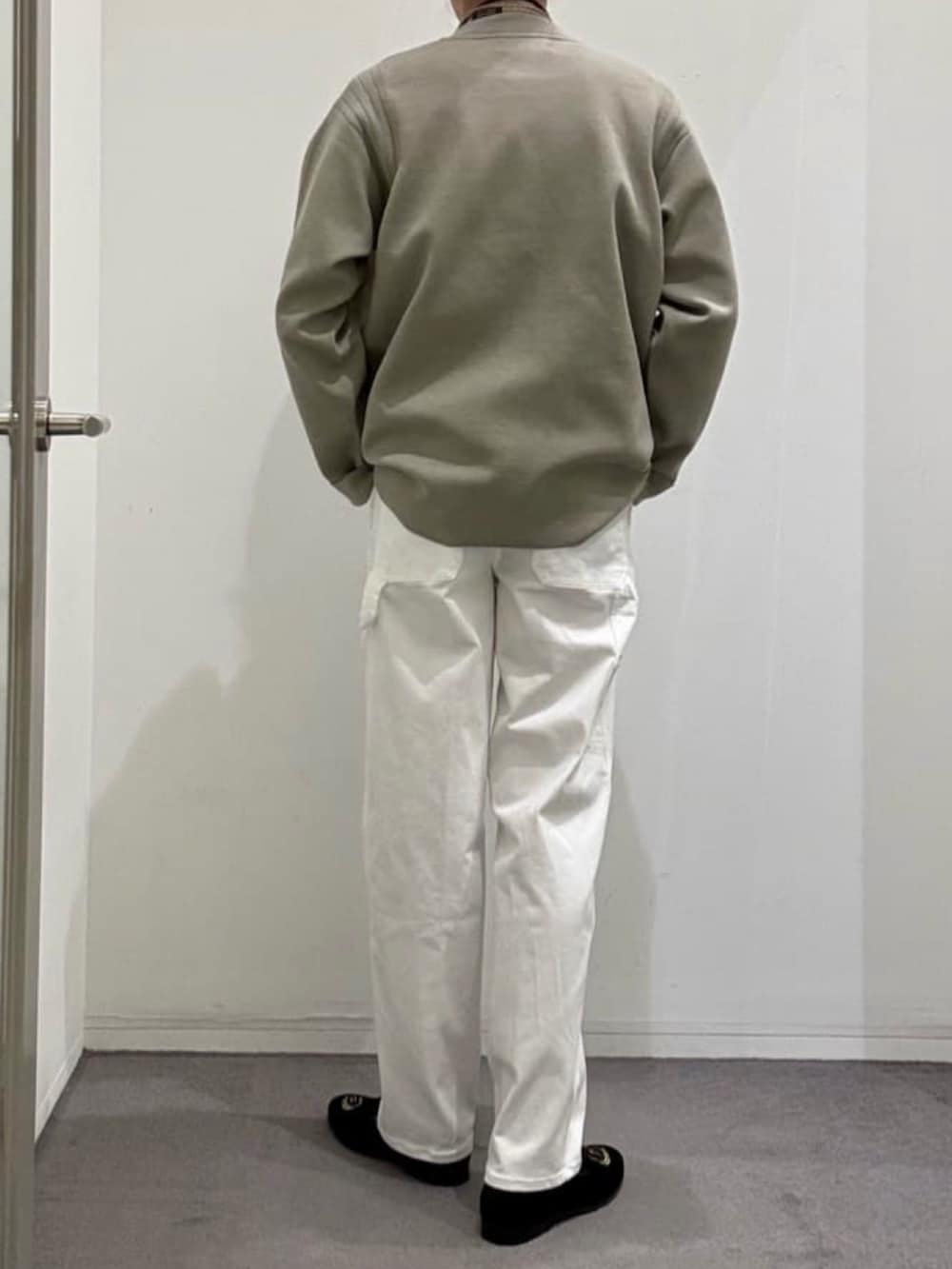 ブラック系のドレスシューズ、ホワイト系のデニムパンツ、ベージュ系のニット/セーターを着用したメンズの春コーディネートの3枚目の写真