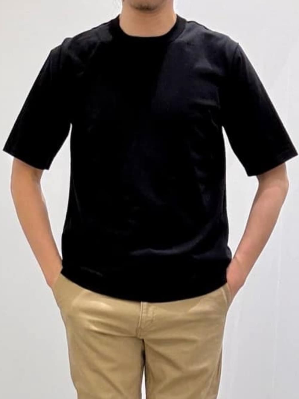 グレー系のスリッポン、ベージュ系のスラックス、ブラック系のニット/セーターを着用したメンズの夏コーディネートの6枚目の写真
