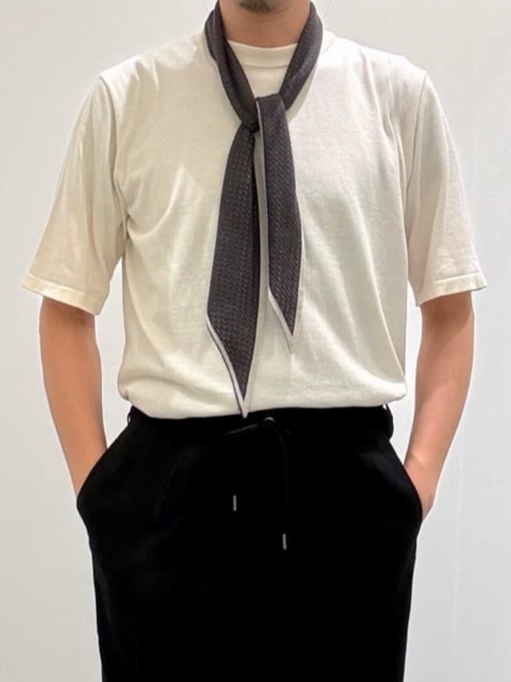 ブラック系のスラックス、ホワイト系のカーディガン/ボレロ、ホワイト系のニット/セーターを着用したメンズの夏コーディネートの7枚目の写真