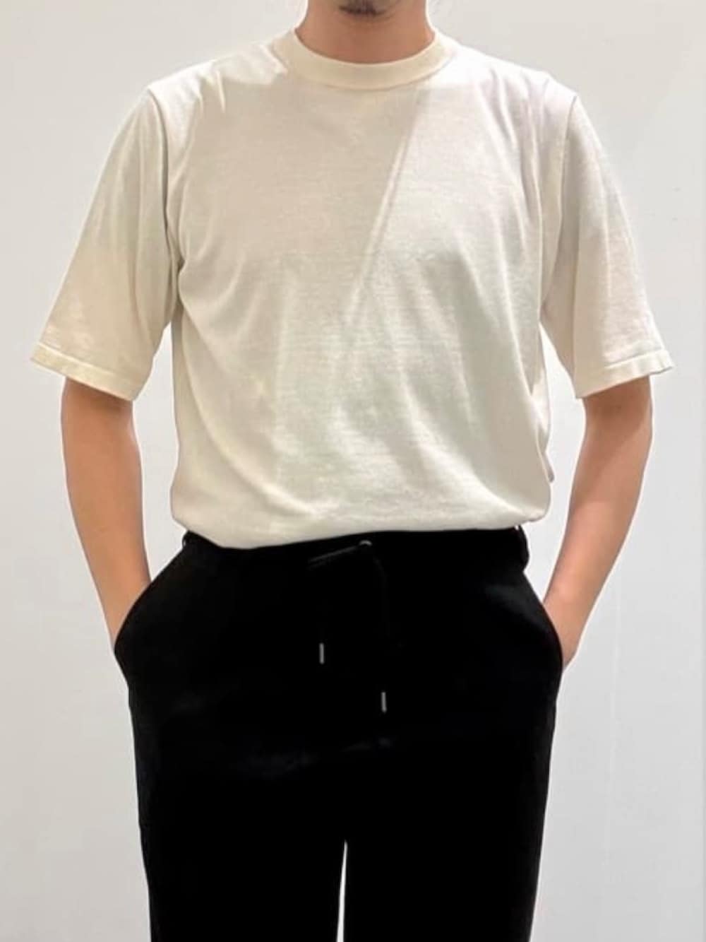 ブラック系のスラックス、ホワイト系のカーディガン/ボレロ、ホワイト系のニット/セーターを着用したメンズの夏コーディネートの8枚目の写真