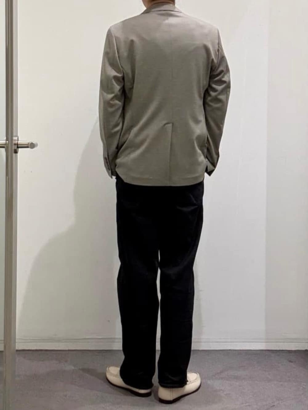 ベージュ系のスリッポン、ブラック系のデニムパンツ、ホワイト系のニット/セーターを着用したメンズの春コーディネートの3枚目の写真