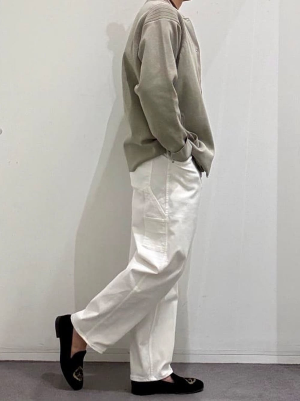 ブラック系のドレスシューズ、ホワイト系のデニムパンツ、ベージュ系のニット/セーターを着用したメンズの春コーディネートの2枚目の写真