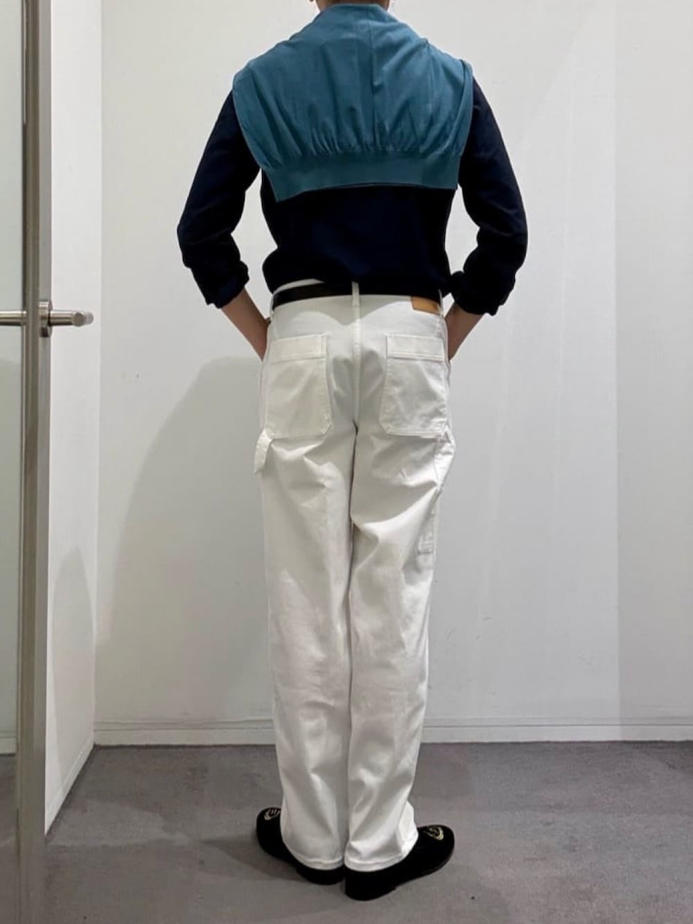 ブラック系のドレスシューズ、ホワイト系のデニムパンツ、ブルー系のニット/セーターを着用したメンズの春コーディネートの3枚目の写真