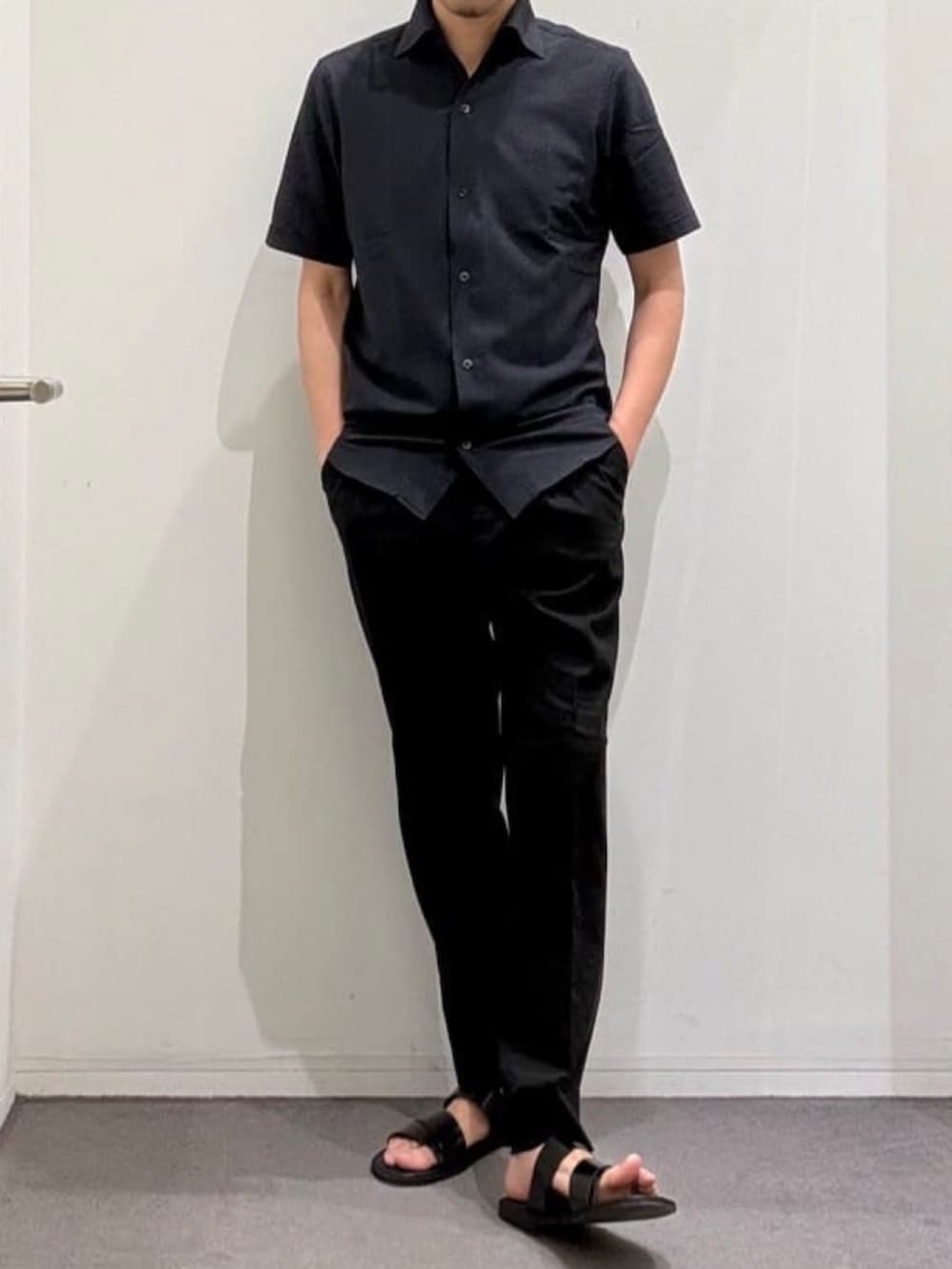グレー系のシャツ/ブラウス、ブラック系のスラックス、ブラック系のサンダルを着用したメンズの夏コーディネートの2枚目の写真