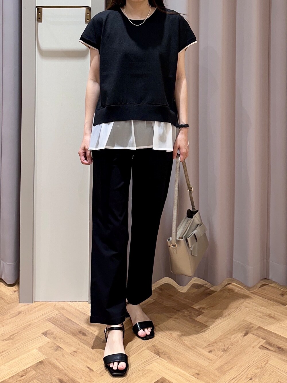 ブラック系のニット/セーター、ブラック系のその他パンツ、シルバー系のショルダーバッグを着用したレディースの夏コーディネートの4枚目の写真