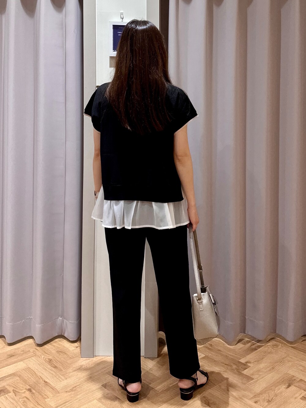 ブラック系のニット/セーター、ブラック系のその他パンツ、シルバー系のショルダーバッグを着用したレディースの夏コーディネートの3枚目の写真