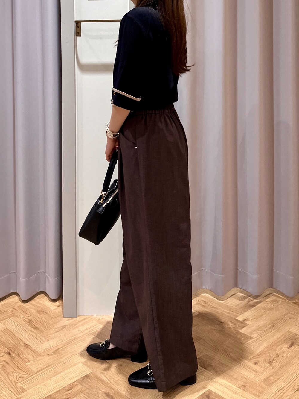 ブラック系のニット/セーター、ブラウン系のその他パンツ、ブラック系のショルダーバッグを着用したレディースの夏コーディネートの5枚目の写真