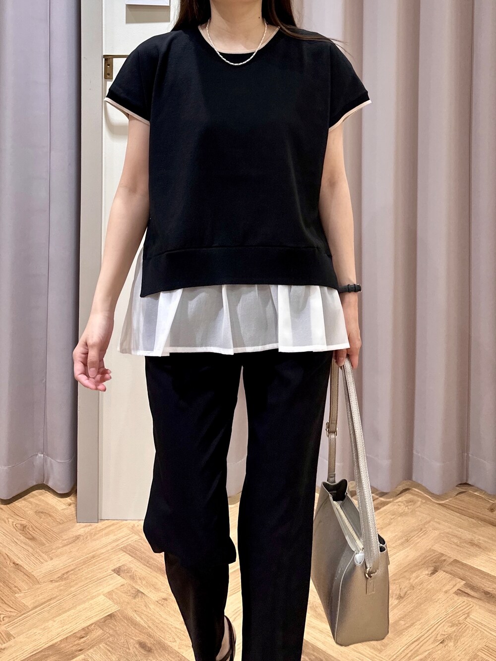 ブラック系のニット/セーター、ブラック系のその他パンツ、シルバー系のショルダーバッグを着用したレディースの夏コーディネートの6枚目の写真