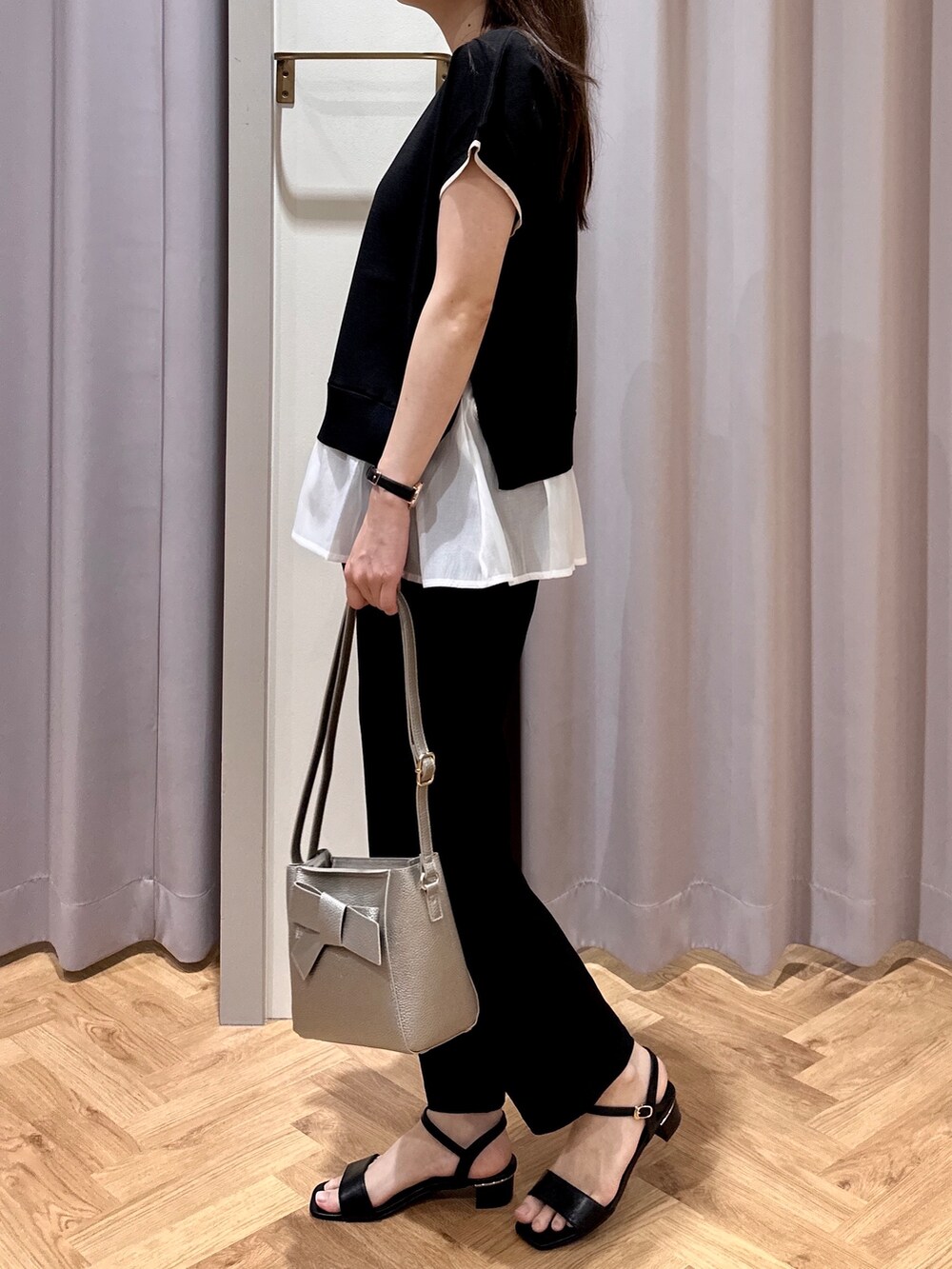 ブラック系のニット/セーター、ブラック系のその他パンツ、シルバー系のショルダーバッグを着用したレディースの夏コーディネートの5枚目の写真