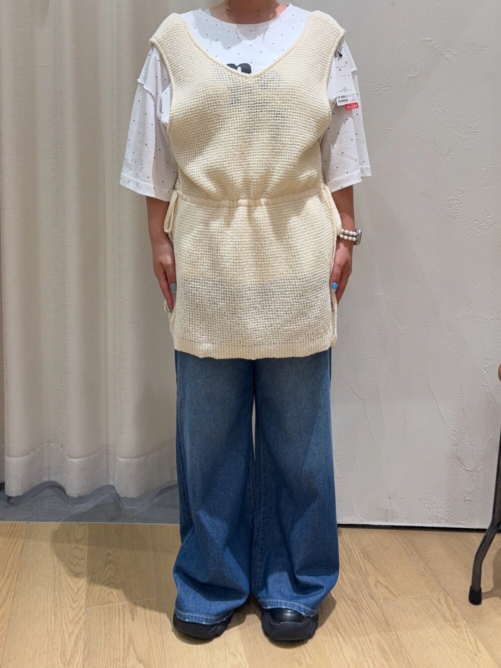 ホワイト系のベスト、ホワイト系のTシャツ/カットソー、ブルー系のデニムパンツを着用したレディースの夏コーディネートの3枚目の写真