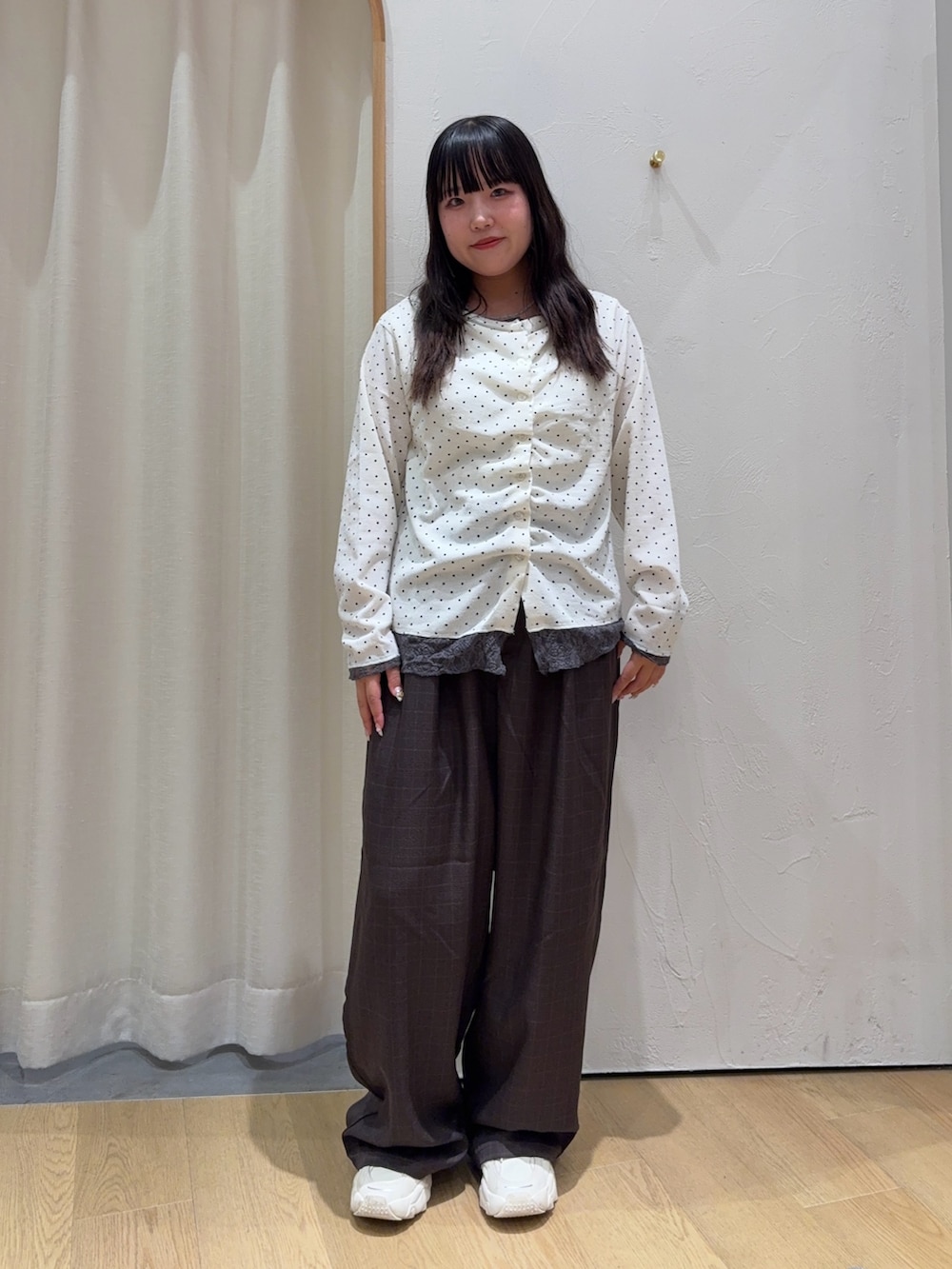 ホワイト系のカーディガン/ボレロ、グレー系のスラックスを着用したレディースの秋コーディネートの2枚目の写真
