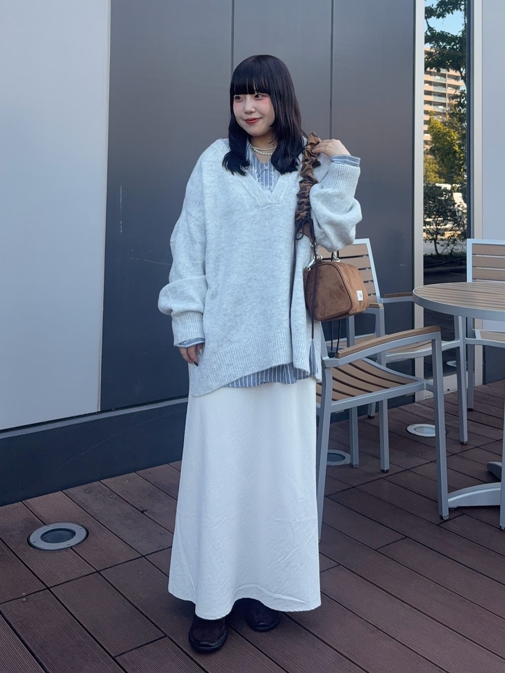 ホワイト系のニット/セーター、ブルー系のシャツ/ブラウス、イエロー系のショルダーバッグを着用したレディースの秋コーディネートの3枚目の写真