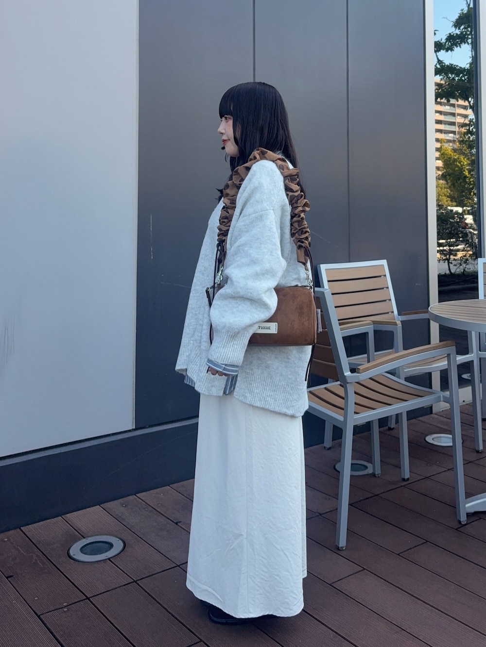 ホワイト系のニット/セーター、ブルー系のシャツ/ブラウス、イエロー系のショルダーバッグを着用したレディースの秋コーディネートの5枚目の写真