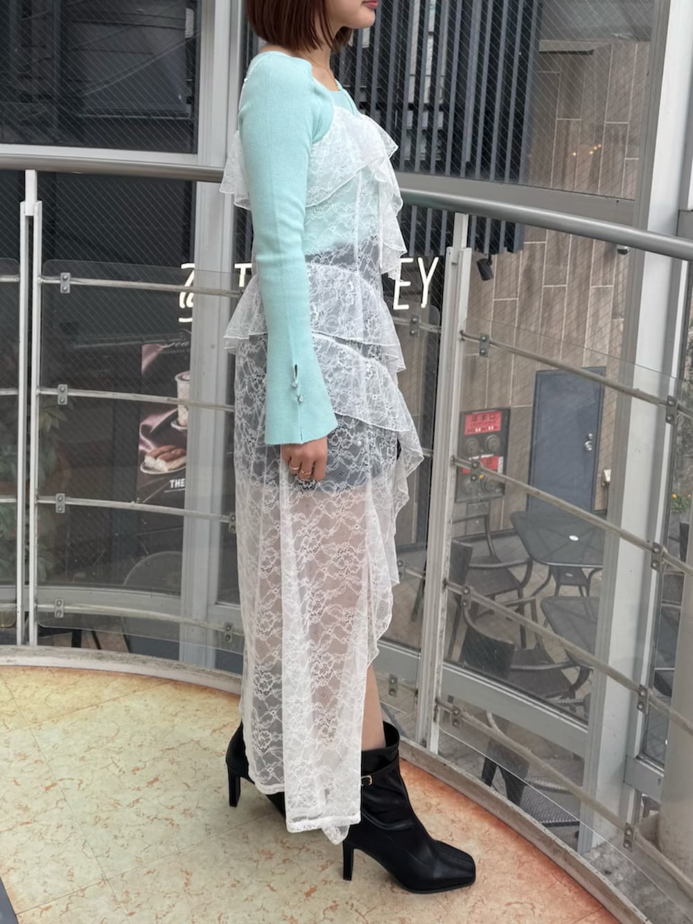 グリーン系のニット/セーター、ブルー系のデニムパンツ、ブラック系のブーツを着用したレディースの冬コーディネートの3枚目の写真