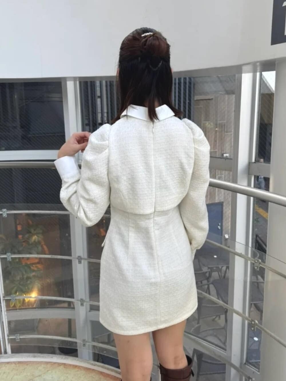 ホワイト系のワンピース、ブラウン系のブーツを着用したレディースの冬コーディネートの6枚目の写真