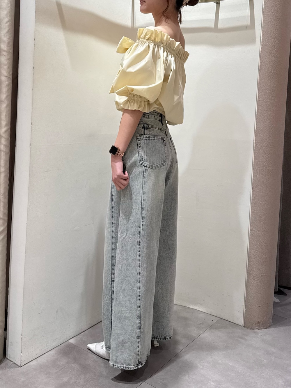 ブルー系のデニムパンツ、ホワイト系のパンプス、イエロー系のシャツ/ブラウスを着用したレディースの春コーディネートの3枚目の写真